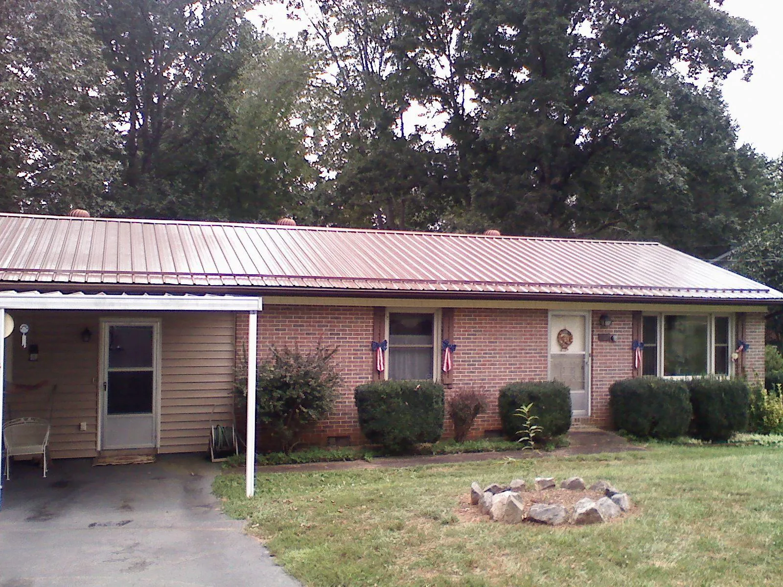 Bronze metal roof and carport on a brick ranch home — Roof Repair work by our crew in Saint Augustine