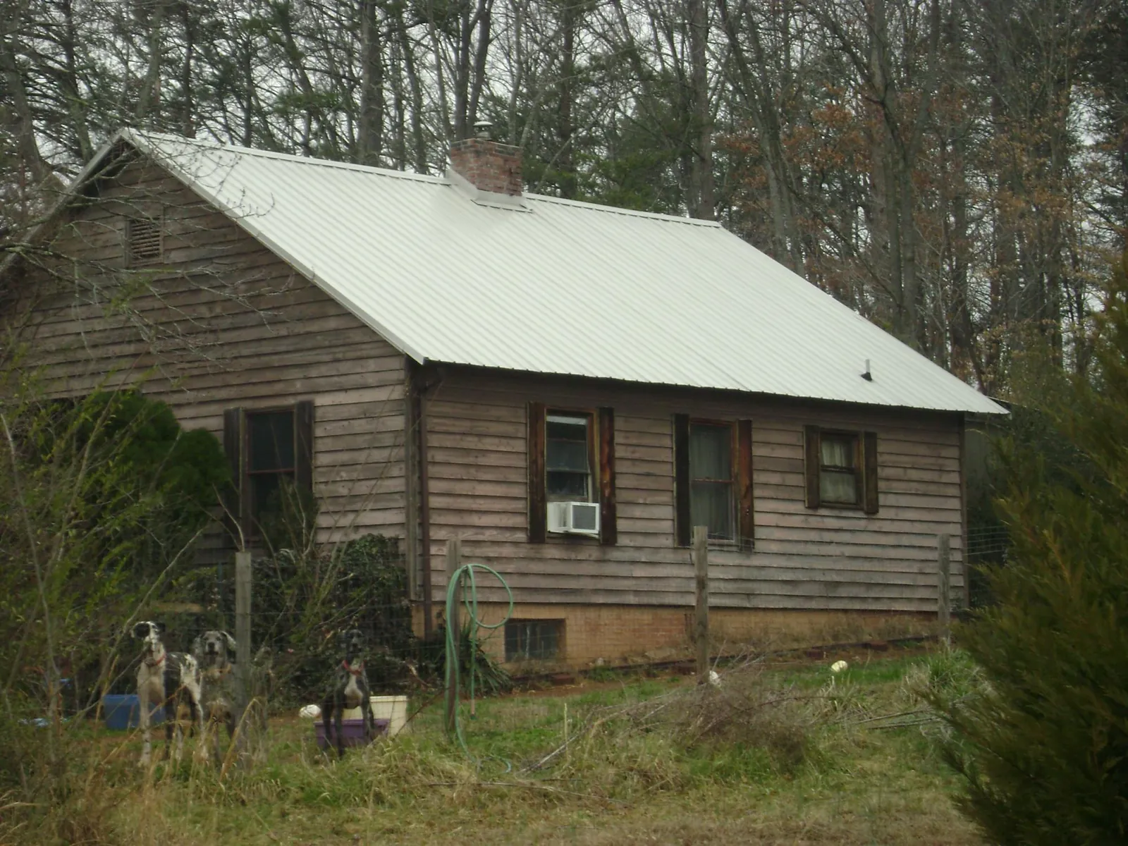White metal roof on an old wood sided farmhouse, from a Metal Roof Installation job in Saint Augustine
